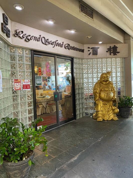 Entrance of Legend Seafood Restaurant in downtown Honolulu with a golden Buddha statue